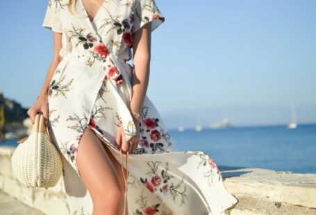 Fashion - woman walking on seaside while holding woven bag